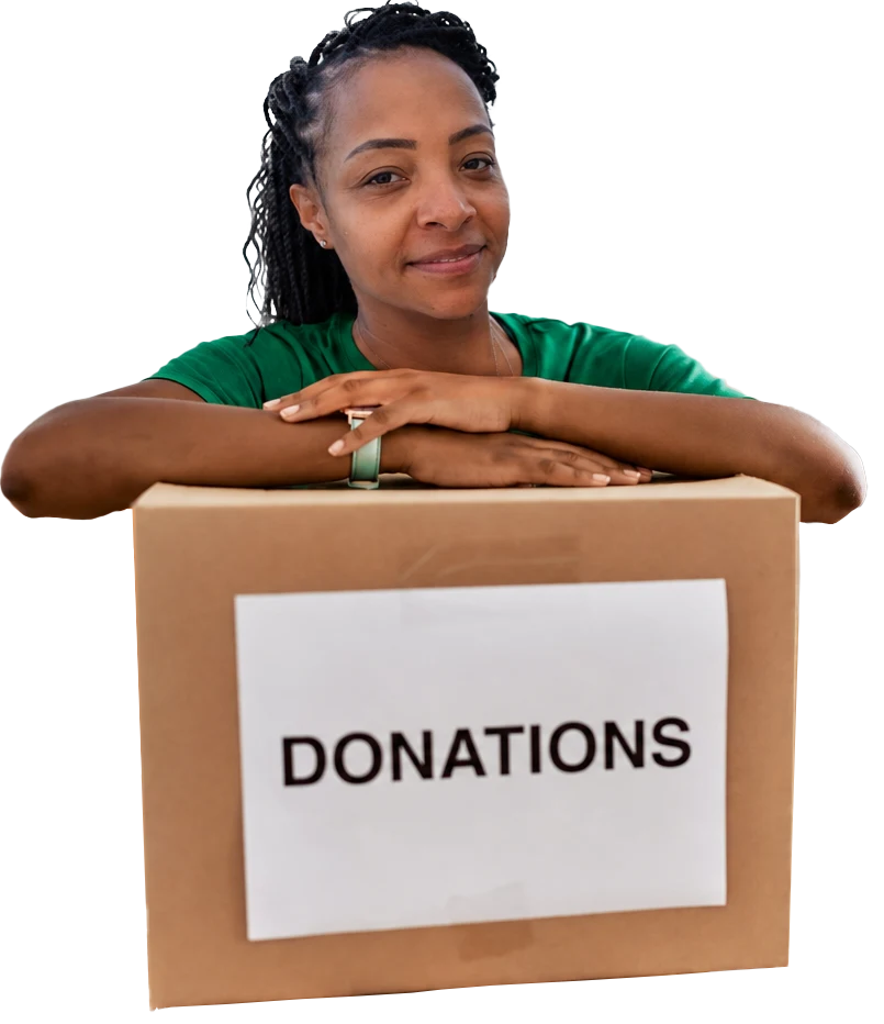 The founder Lizz Willett leaning on a cardboard box that has a large Donations attached to it