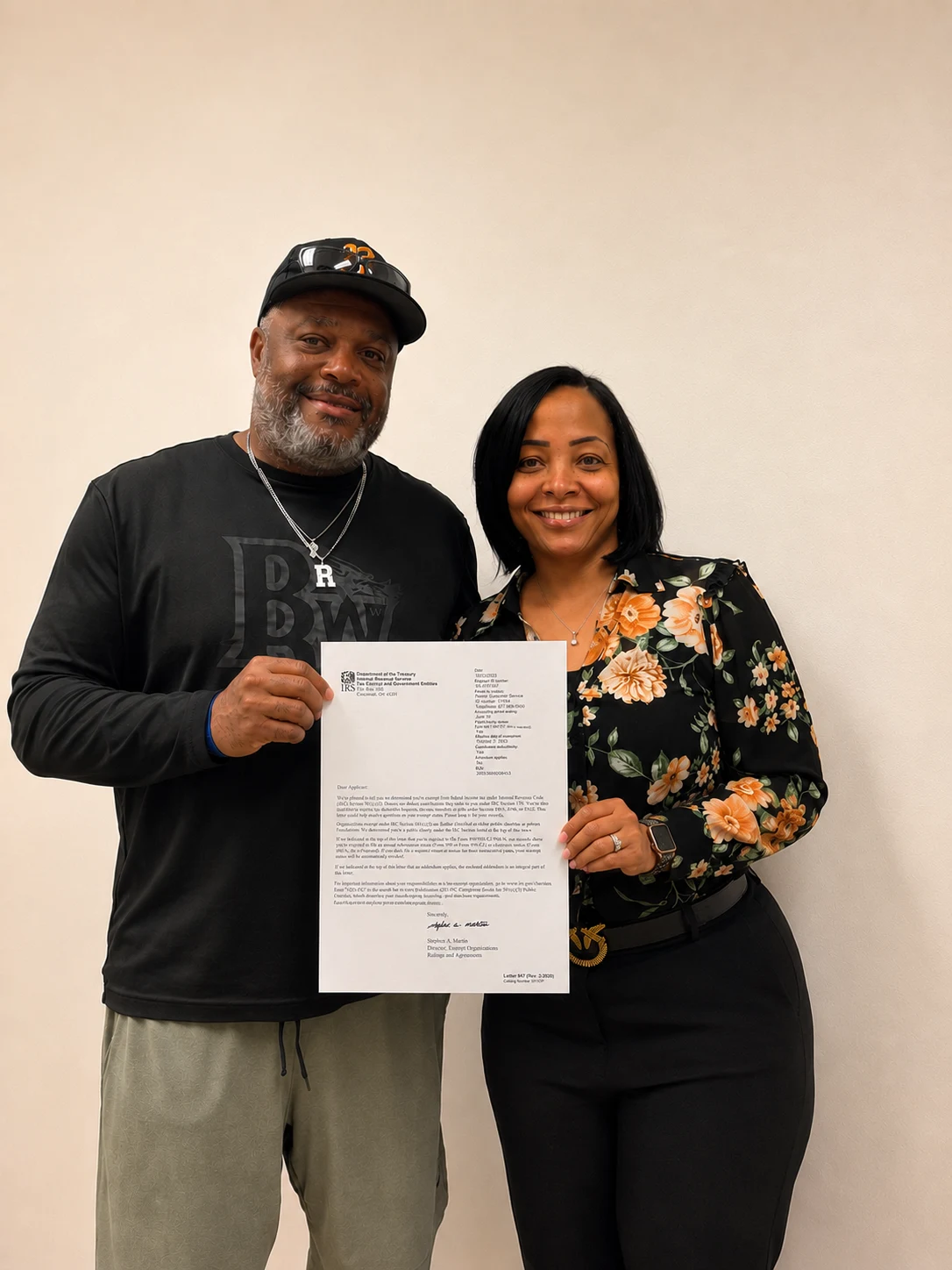 The founder Lizz and her husband proudly are holding up together the IRS nonprofit determination Letter