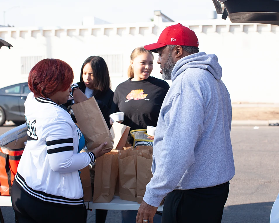 The founding family and other volunteers are packaging food items at the Christmas food giveaway in Phoenix, AZ