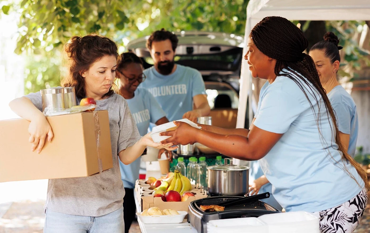 Volunteers providing food items at a charity event