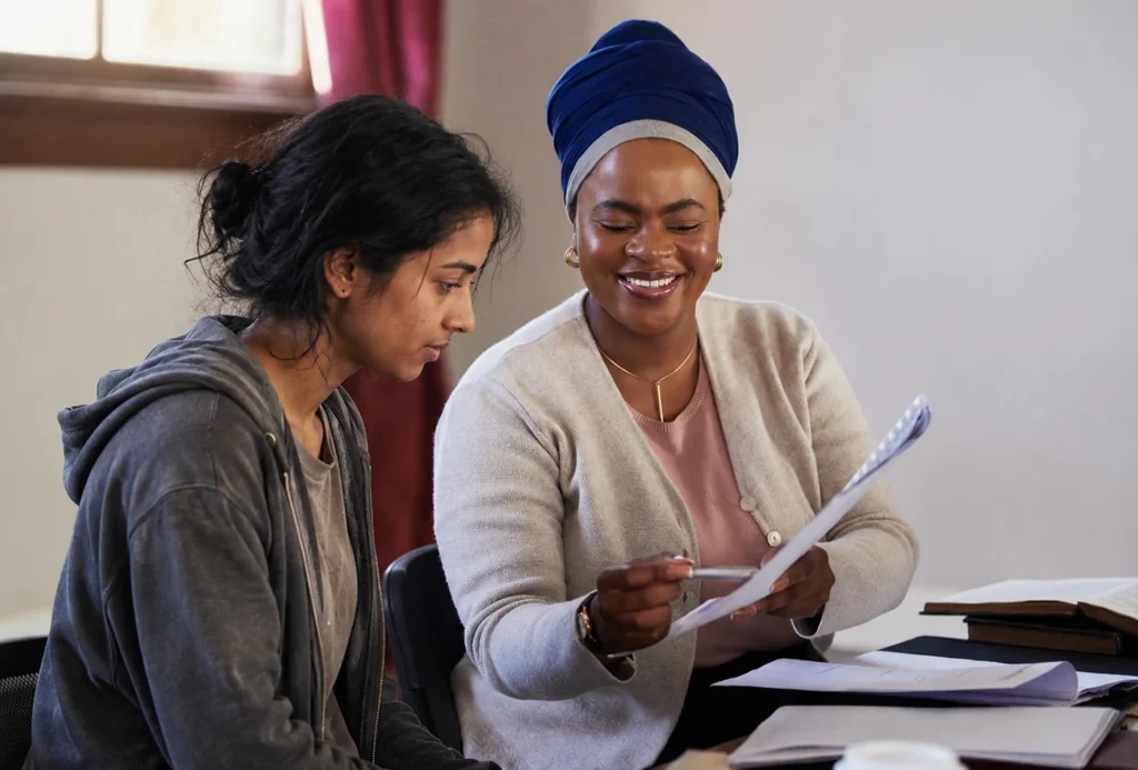 A woman facing housing hardship sits in the office together with a social worker going over papaer work